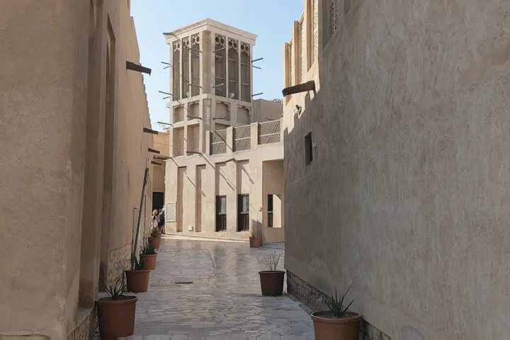 Two narrow alley walls converge towards a wind tower in the Al Fahidi quarter.